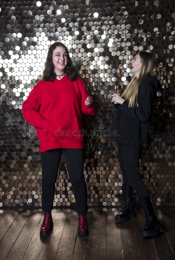 Zwei Teenagermädchen lachen über die goldene Mauer. lizenzfreies stockfoto