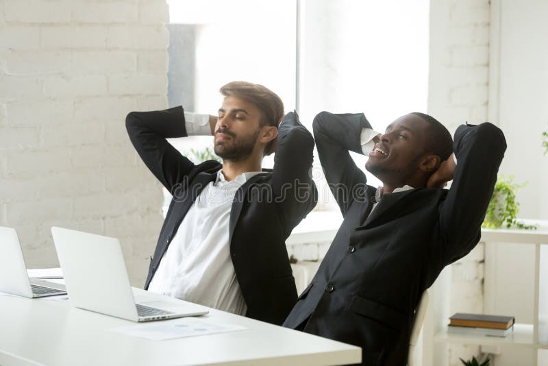 Zwei verschiedene junge Geschäftsmänner, die bei der Arbeit atmet frisches a sich entspannen