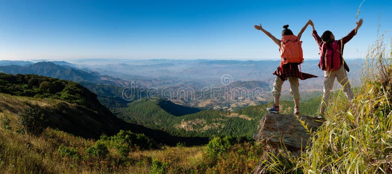 Zwei weibliche Wanderer, die oben Gebirgsklippe klettern lizenzfreies stockbild Zwei weibliche Wanderer, die oben Gebirgsklippe klettern lizenzfreies stockbild