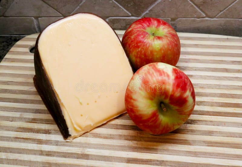Zwei Äpfel und geräucherter Gouda-Käse auf Metzger ` S Block mit Fliesenhintergrund lizenzfreies stockfoto Zwei Äpfel und geräucherter Gouda-Käse auf Metzger ` S Block mit Fliesenhintergrund lizenzfreies stockfoto