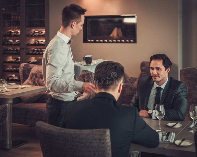 Zwei überzeugte Geschäftsleute essen Business-Lunch am Restaurant zu Mittag stockfotografie Zwei überzeugte Geschäftsleute essen Business-Lunch am Restaurant zu Mittag stockfotografie
