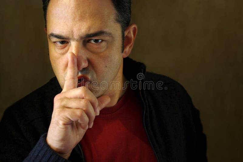 Man holding a finger on his mouth demanding silence. Man holding a finger on his mouth demanding silence.