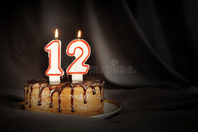 Zwölf Jahre Jahrestag Geburtstagsschokoladenkuchen mit weißen brennenden Kerzen in Form von Nr. zwölf stockbild Zwölf Jahre Jahrestag Geburtstagsschokoladenkuchen mit weißen brennenden Kerzen in Form von Nr. zwölf stockbild