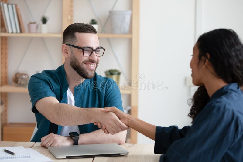 Zâmbește managerul strângându-și mâinile cu un candidat african american. stock photo