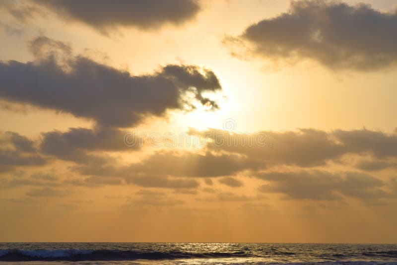 Złoci Sunrays przychodzi przez Ciemnych chmur nad morzem przy wieczór fotografia stock Złoci Sunrays przychodzi przez Ciemnych chmur nad morzem przy wieczór fotografia stock