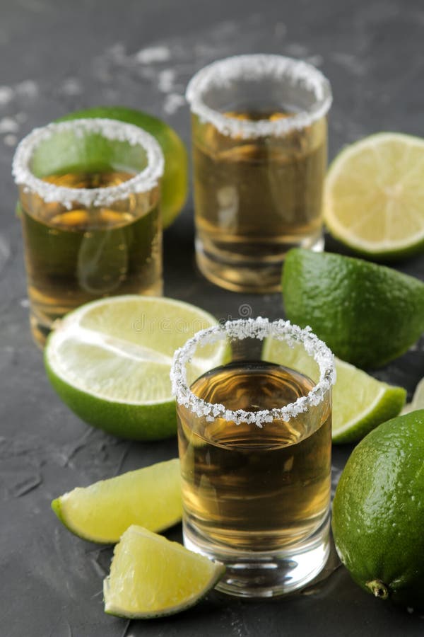 Złocisty tequila w szklanym strzału szkle z solą i wapnem zamkniętymi w górę czarnego betonowego tła dalej bar napoje alkoholowe obrazy stock Złocisty tequila w szklanym strzału szkle z solą i wapnem zamkniętymi w górę czarnego betonowego tła dalej bar napoje alkoholowe obrazy stock
