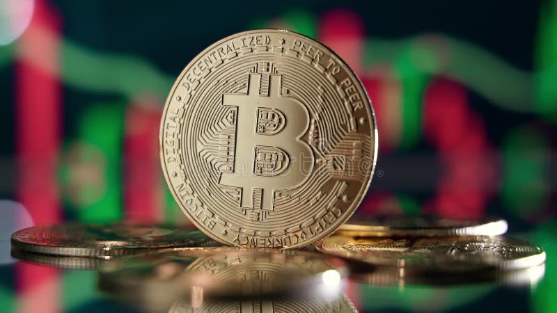 Złota bitcoina wyizolowana na tle z kartą kryptograficzną z zielonymi i czerwonymi świecznikami