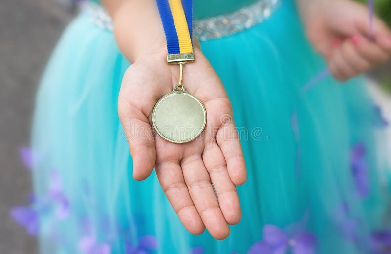 Złoty medal przy dziewczyny ręką Kończący studia od dziecina obrazy royalty free Złoty medal przy dziewczyny ręką Kończący studia od dziecina obrazy royalty free