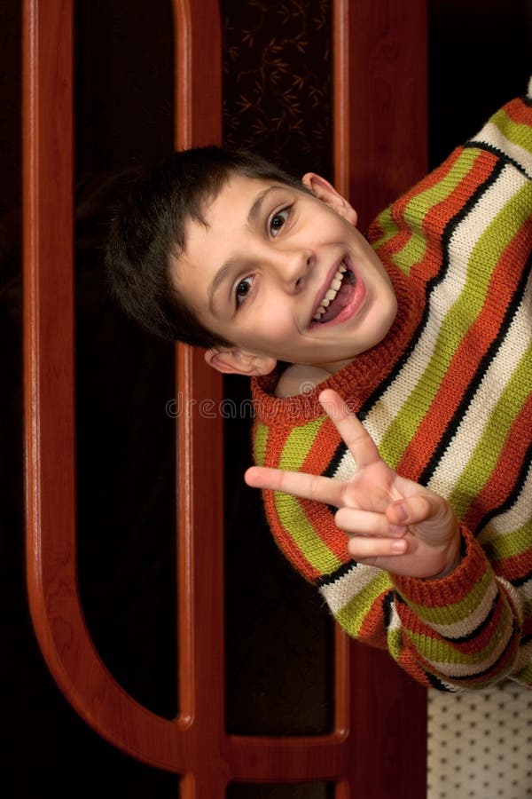 A happy boy is looking out of the doorway. A happy boy is looking out of the doorway