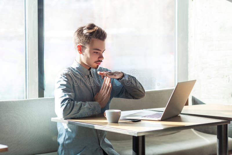 ¡Tiempo hacia fuera! El retrato de la vista lateral de advertir al freelancer joven barbudo hermoso en camisa azul se está sentan imagen de archivo ¡Tiempo hacia fuera! El retrato de la vista lateral de advertir al freelancer joven barbudo hermoso en camisa azul se está sentan imagen de archivo