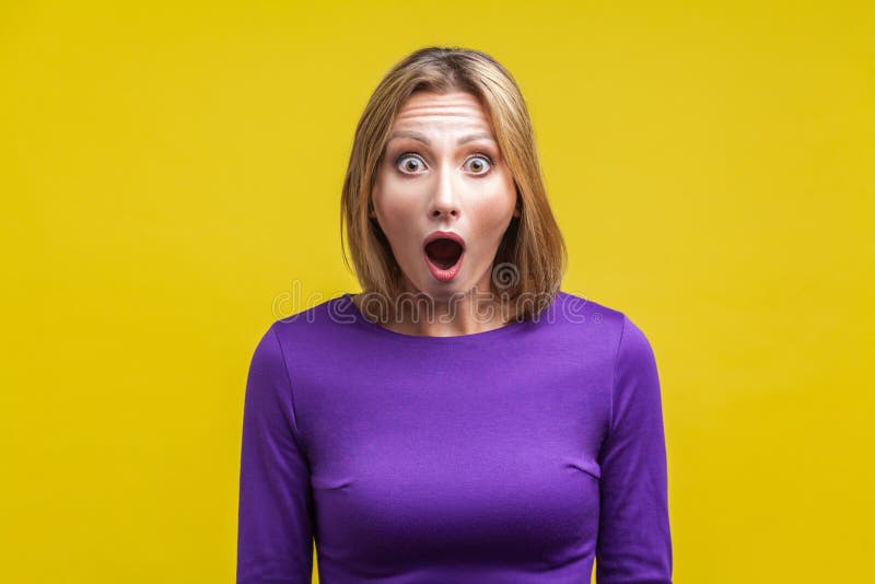¡Wow, no puedo creer esto! Retrato de una mujer sorprendida con la cara sorprendida estudio interior aislado en amarillo imagen de archivo libre de regalías