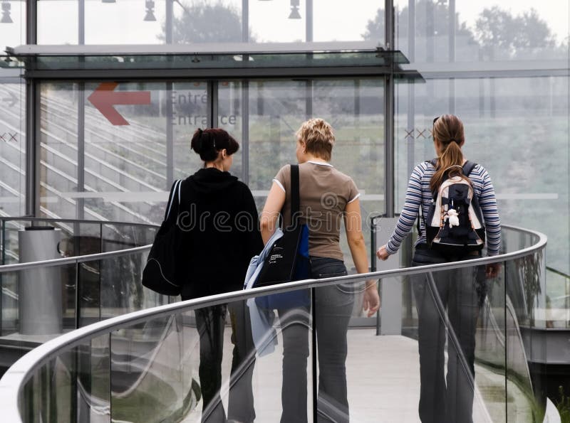 Three girls entering a college building. Three girls entering a college building.