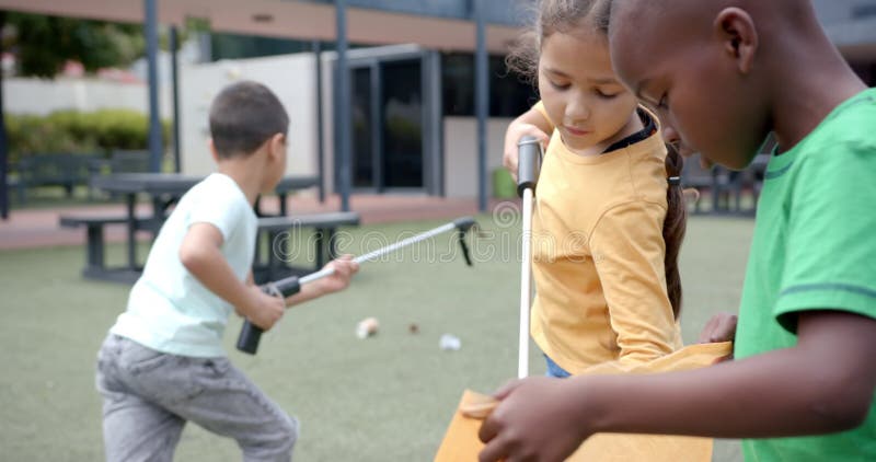 À l'école, les enfants nettoient l'aire de jeux à l'aide de grabbers et de sacs à ordures banque de vidéos