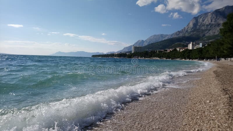 Água azul, praia, montanhas, verão fotografia de stock