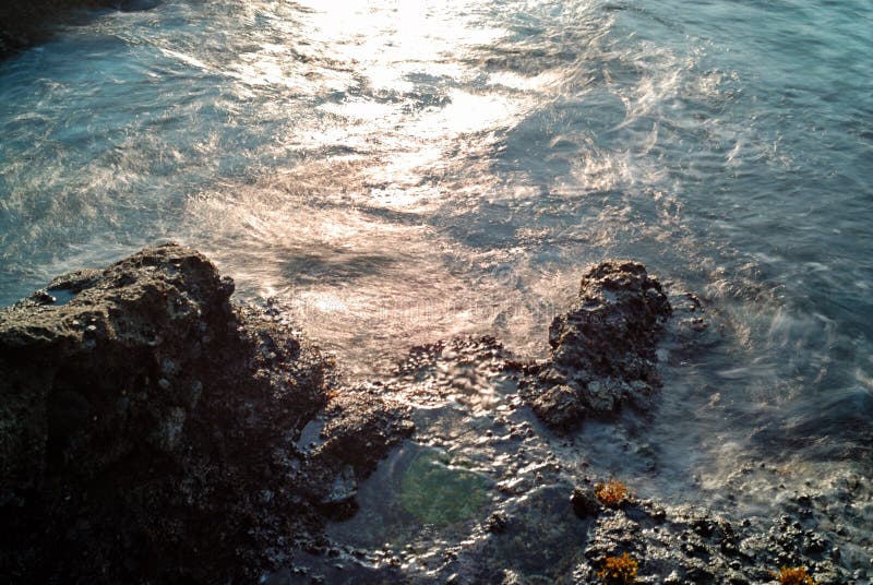 A água do oceano que espirra na costa rochosa foto de stock A água do oceano que espirra na costa rochosa foto de stock
