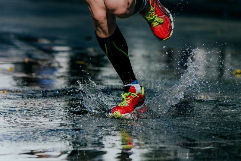 A água espirra de debaixo de seus tênis de corrida imagem de stock A água espirra de debaixo de seus tênis de corrida imagem de stock