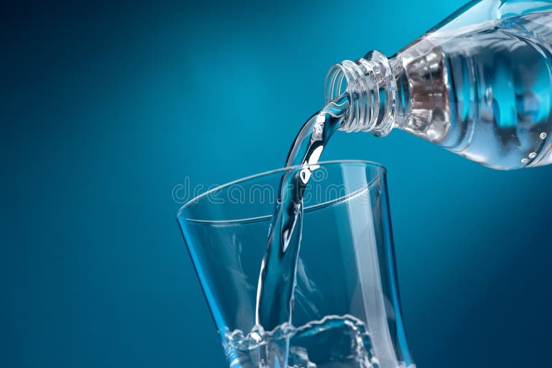 Pouring fresh mineral water from a bottle into a glass, hydration and diet concept. Pouring fresh mineral water from a bottle into a glass, hydration and diet concept