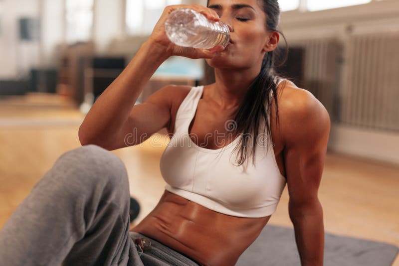 Água potável da mulher da aptidão da garrafa no gym