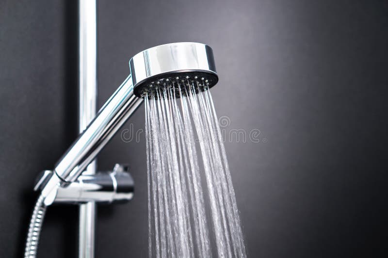 Água que corre da cabeça de chuveiro no banheiro