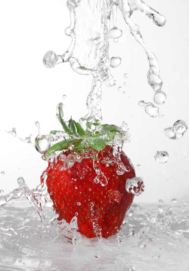 Água que está sendo derramada dentro uma morango imagens de stock Água que está sendo derramada dentro uma morango imagens de stock