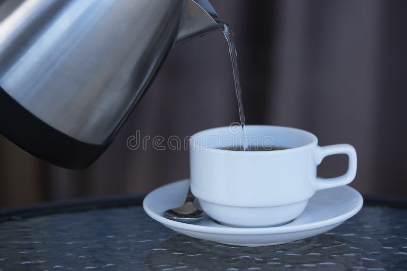 Água quente de derramamento que faz o café quente foto de stock Água quente de derramamento que faz o café quente foto de stock