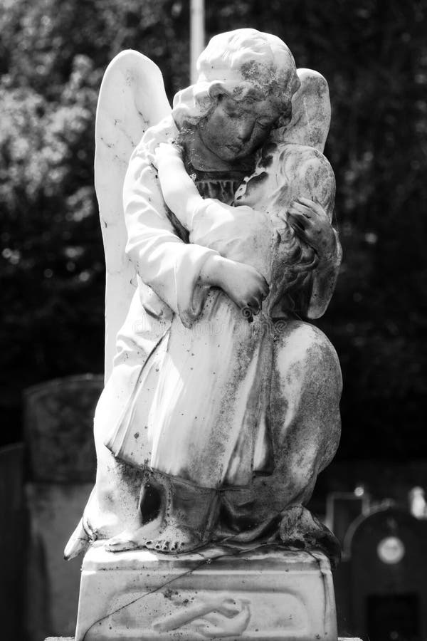 ángel de piedra monocromo sostiene a un niño. ángel de piedra sosteniendo a un niño. detalles de una fosa común en nederename belgium. nedername es un pueblo de la provincia belga de flanders orientales y un submunicipio de oudenaarde. el cementerio histórico es uno de los más bellos de la región. se presta especial atención al mantenimiento ecológico y respetuoso con el medio ambiente del cementerio.