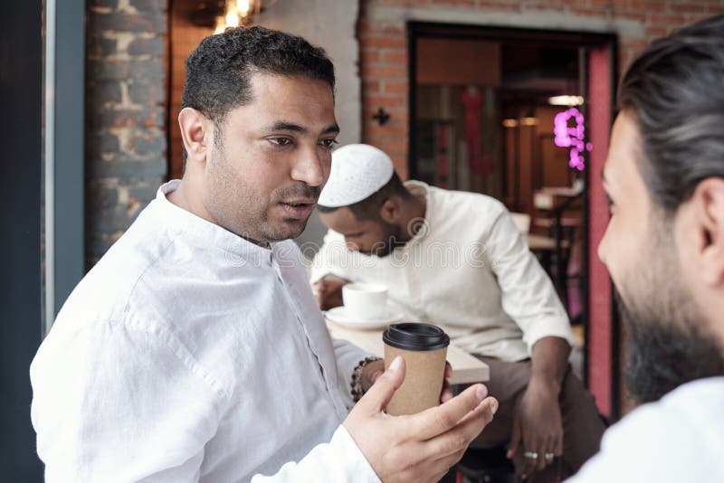 árabe bebendo café com amigo