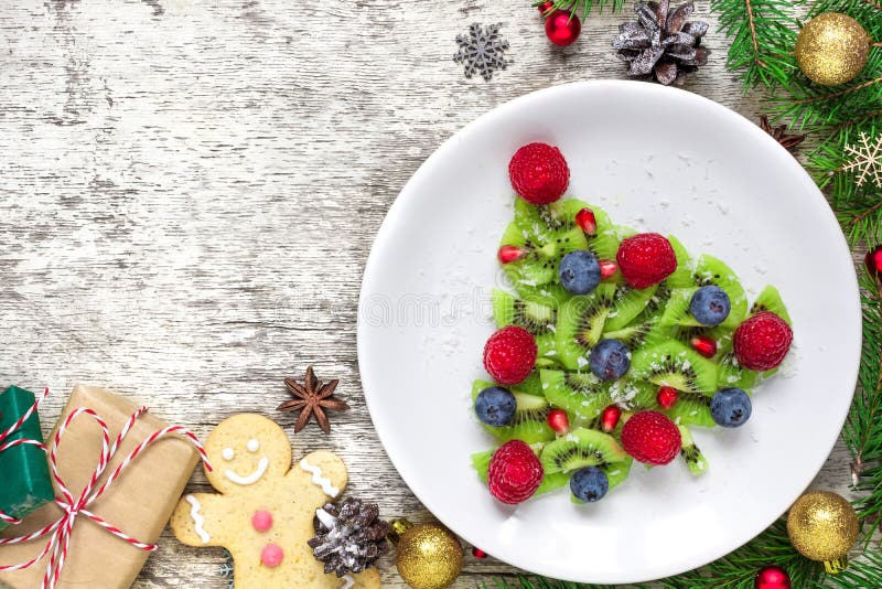 Árbol de navidad del kiwi con las ramas de árbol de abeto y las cajas de regalo sobre la tabla de madera blanca idea divertida de fotos de archivo libres de regalías Árbol de navidad del kiwi con las ramas de árbol de abeto y las cajas de regalo sobre la tabla de madera blanca idea divertida de fotos de archivo libres de regalías