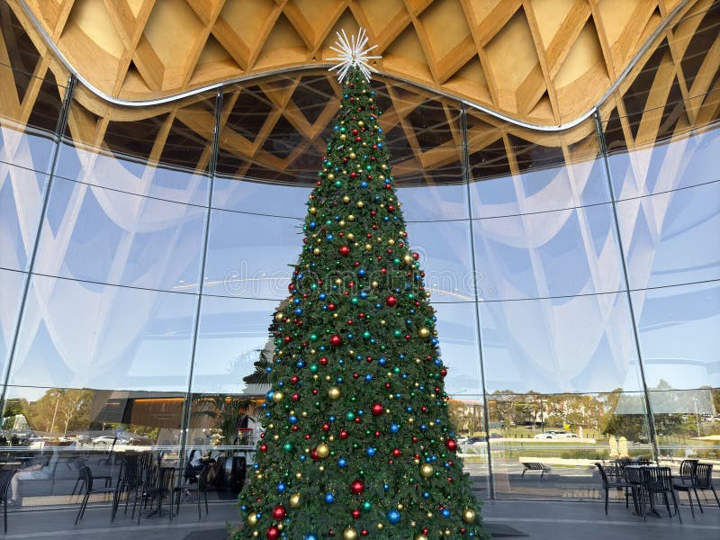 árbol de navidad en bunjil place con arquitectura de ventana durante diciembre de 2024. Vista angular del árbol de navidad en la entrada de la arquitectura con campanas durante el verano
