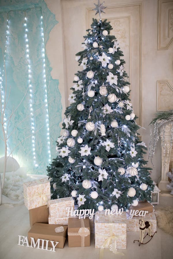 White studio light room design decorative x-mas tree, big hall prepare and decorated for Christmas & New Year party. Big glass balls and presents for children from parents. Fairy tale family art idea. White studio light room design decorative x-mas tree, big hall prepare and decorated for Christmas & New Year party. Big glass balls and presents for children from parents. Fairy tale family art idea