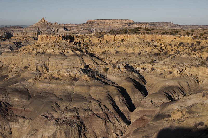 Overlook on the canyons and desert of Angel Peak scenic area, with multicolor eroded sandstone formations and a clear blue sky. Overlook on the canyons and desert of Angel Peak scenic area, with multicolor eroded sandstone formations and a clear blue sky