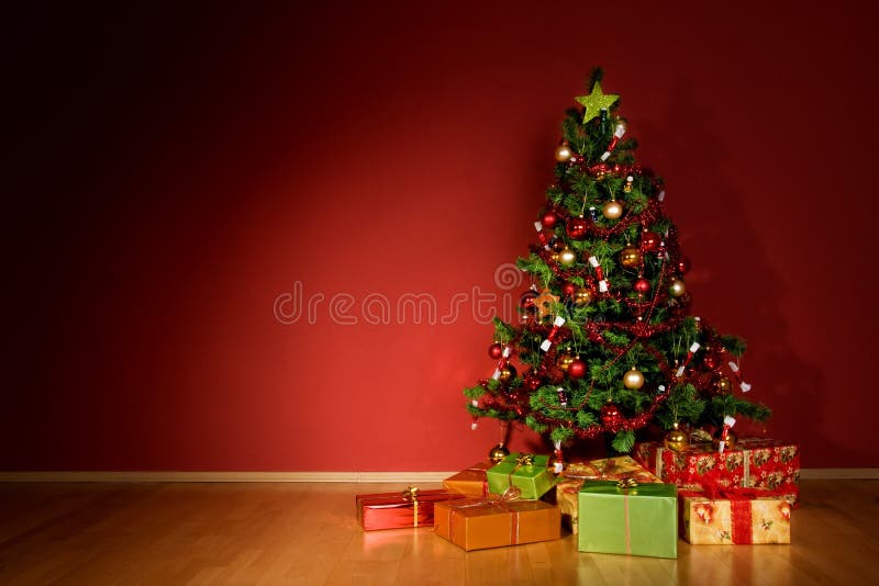 Árvore de Natal com presentes de Natal num quarto vermelho imagens de stock