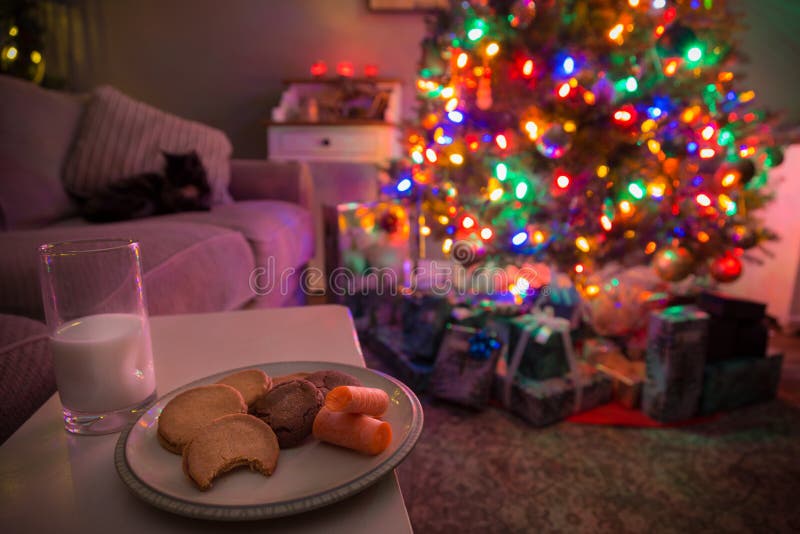 Árvore de Natal com os presentes sob ela e cookies e leite deixados para fora para Santa e a rena imagens de stock royalty free Árvore de Natal com os presentes sob ela e cookies e leite deixados para fora para Santa e a rena imagens de stock royalty free