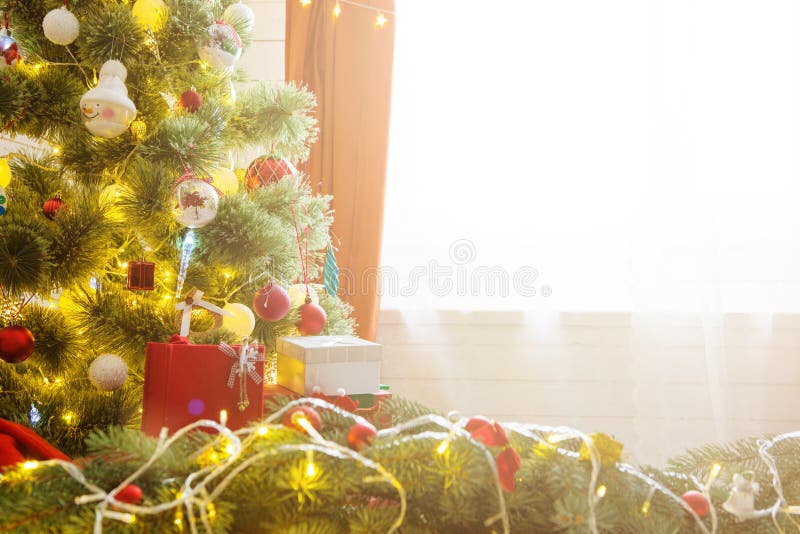 Árvore de Natal elegante com decorações e presentes no assoalho de folhosa elegante sobre a janela foto de stock Árvore de Natal elegante com decorações e presentes no assoalho de folhosa elegante sobre a janela foto de stock