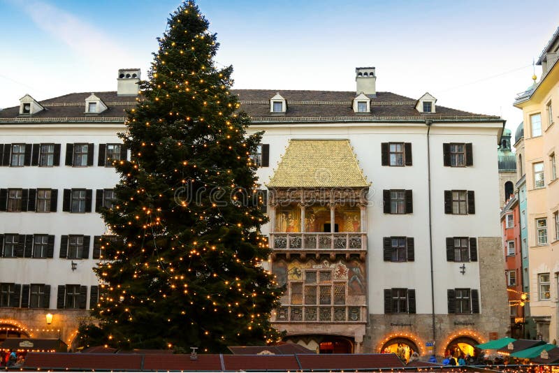 Árvore de Natal enorme na frente do telhado dourado em Áustria fotografia de stock Árvore de Natal enorme na frente do telhado dourado em Áustria fotografia de stock