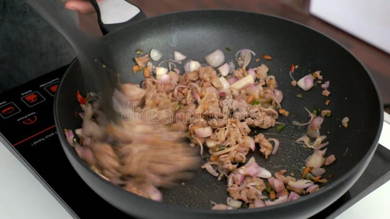 â€ ‹που μαγειρεύει τα ταϊλανδικά τρόφιμα ανακατώνει κοντά τηγανισμένος