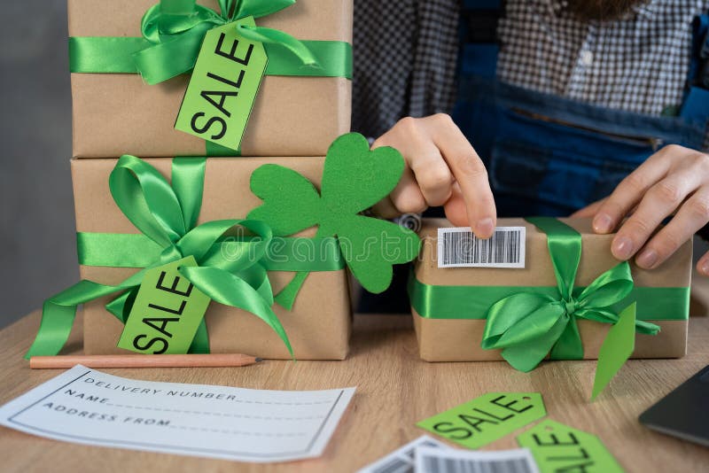 Ägare av manliga småföretag i leprechaun som kontrollerar streckkod för paketlåda. butikssäljare av arbetare royaltyfri bild