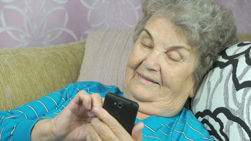 Äldre kvinna som använder en mobiltelefon