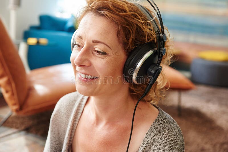 Äldre kvinna som lyssnar till musik med hemmastadd hörlurar