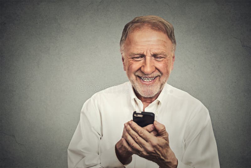 Äldre man som ser hans smarta telefon medan textmessaging arkivbilder Äldre man som ser hans smarta telefon medan textmessaging arkivbilder