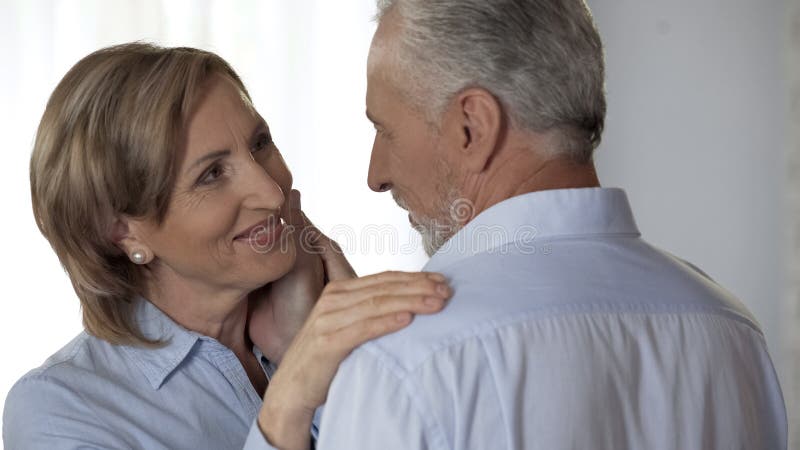 Ältere Dame mit der perfekten Haut, die Ehemann, Ehemann streicht ihr glückliches Gesicht schaut lizenzfreie stockfotos Ältere Dame mit der perfekten Haut, die Ehemann, Ehemann streicht ihr glückliches Gesicht schaut lizenzfreie stockfotos