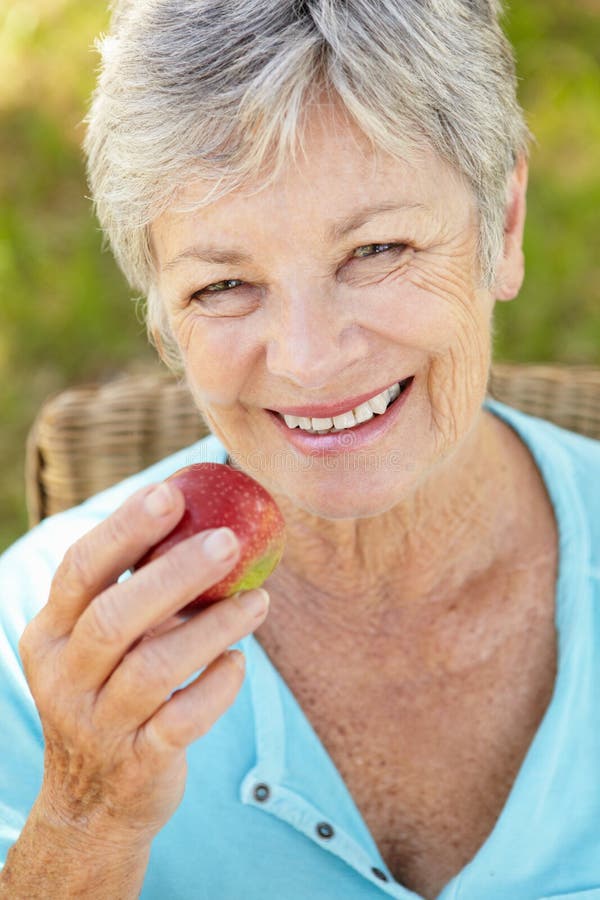 Ältere Frau, die Apfel isst lizenzfreie stockfotos Ältere Frau, die Apfel isst lizenzfreie stockfotos