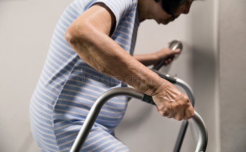 Ältere Frau, die an Handlauf und Wanderer zur Sicherheit hält stockbild Ältere Frau, die an Handlauf und Wanderer zur Sicherheit hält stockbild