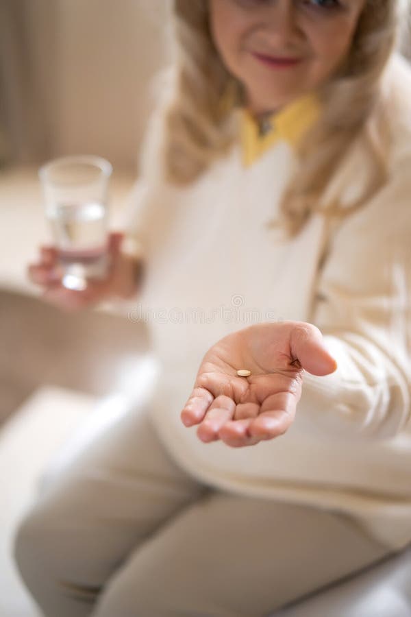 Ältere Frau, die Pillen und ein Glas Wasser hält stockbilder Ältere Frau, die Pillen und ein Glas Wasser hält stockbilder