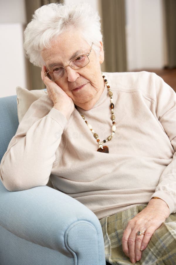 Ältere Frau, die zu Hause traurig schaut