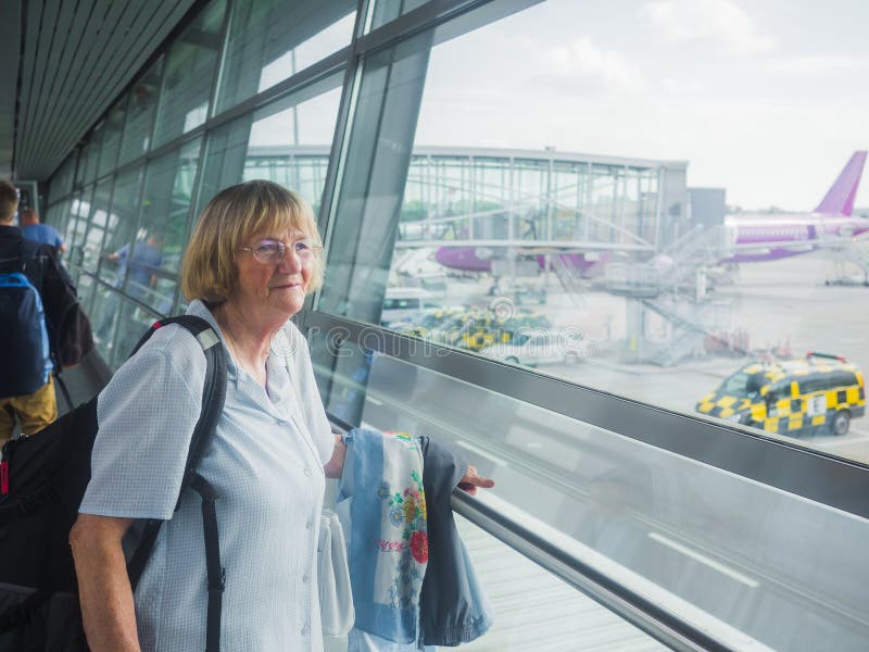 Ältere Frau am Flughafen lizenzfreie stockbilder Ältere Frau am Flughafen lizenzfreie stockbilder