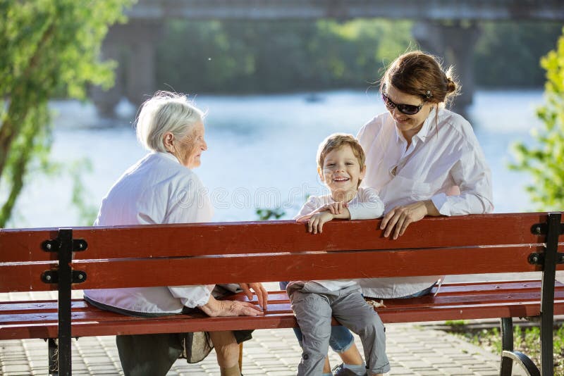 Ältere Frau, ihre erwachsene Enkelin und groß - Enkel im Park lizenzfreies stockfoto Ältere Frau, ihre erwachsene Enkelin und groß - Enkel im Park lizenzfreies stockfoto