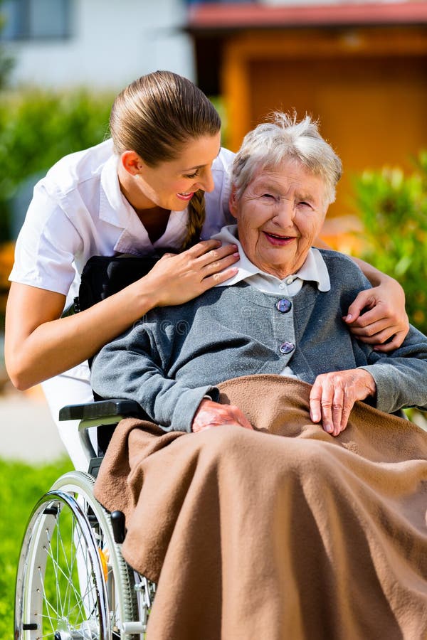 Ältere Frau im Pflegeheim mit Krankenschwester im Garten