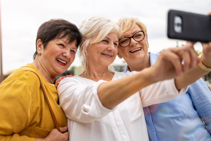 ältere Frauen, die gemeinsam Handy benutzen