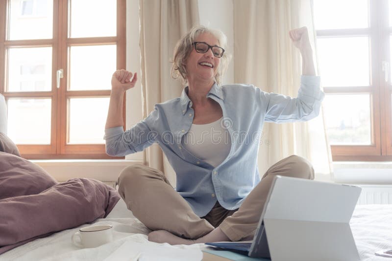 Erfolgreiche ältere Geschäftsfrau, die sich über einen Erfolg freut stockbilder